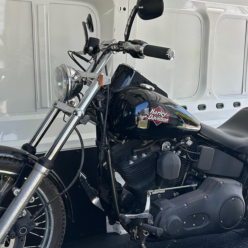 Black Harley-Davidson motorcycle loaded inside a white van