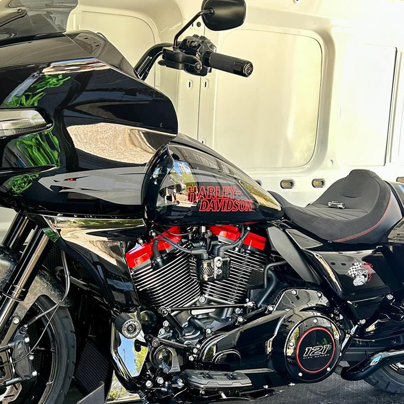 Black Harley-Davidson touring motorcycle with red lettering inside a van