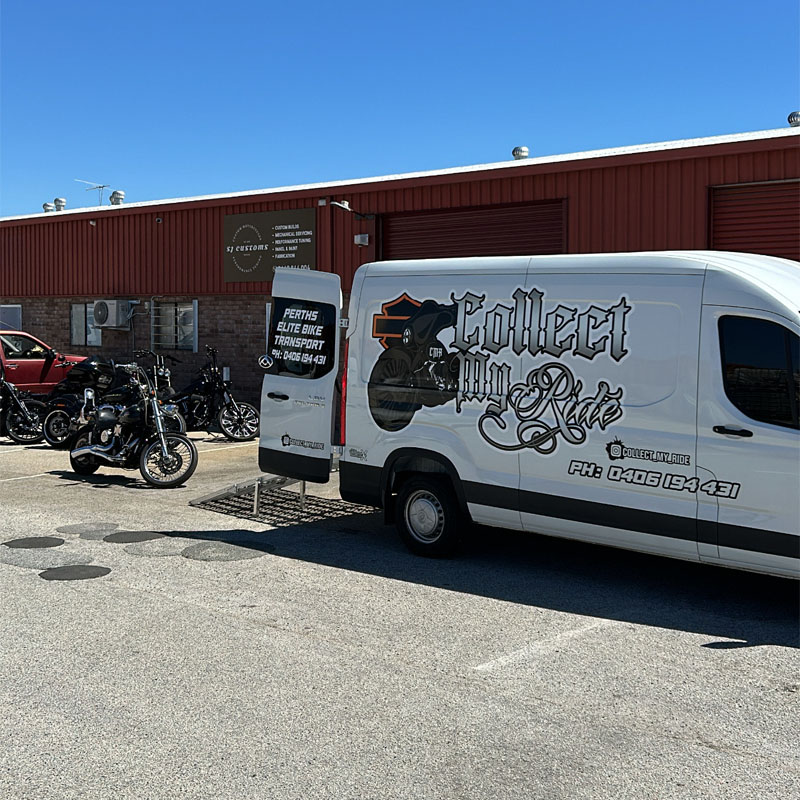 Branded white van with its rear doors open beside parked motorcycles