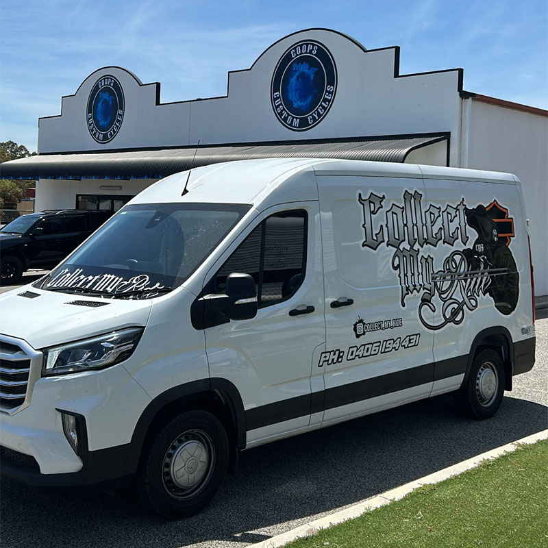 Branded white van parked in front of a shop with round blue signs