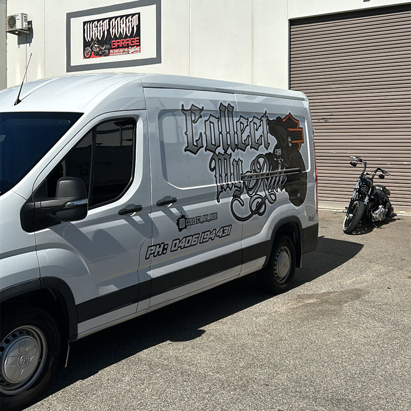 Branded white van outside a garage with a motorcycle by the roller door
