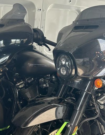 Two black touring motorcycles with fairings side by side in a van