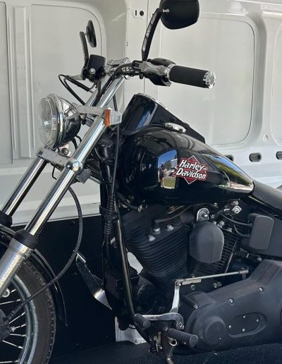 Black Harley-Davidson motorcycle loaded inside a white van