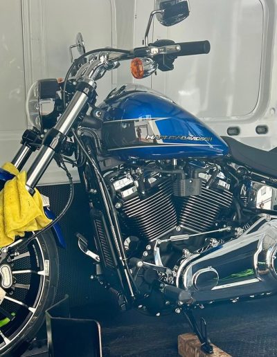 Blue and chrome Harley-Davidson motorcycle strapped inside a van