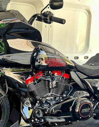 Black Harley-Davidson touring motorcycle with red lettering inside a van